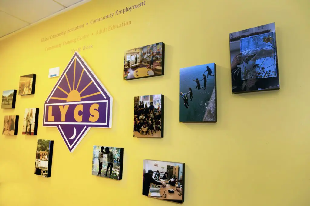 The LYCS logo surrounded by photographs of activities in LYCS. Above the logo reads: Global Citizenship Education, Community Employment, Community Training Centre, Adult Education, Youth Work. Photographed by Paul Reardon.