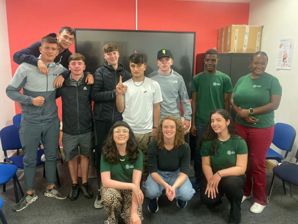 Our Gaisce group pose with a team from GOAL. All participants smile up at the camera.